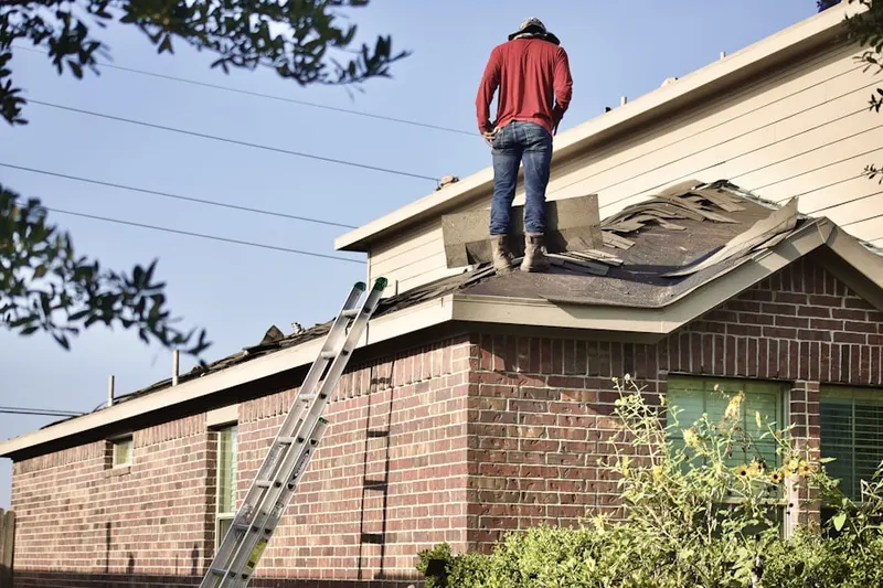Professional roofer working on a residential roof in Orchard Lake
